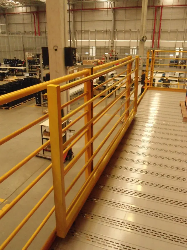 Passarela industrial com guarda-corpo metálico amarelo